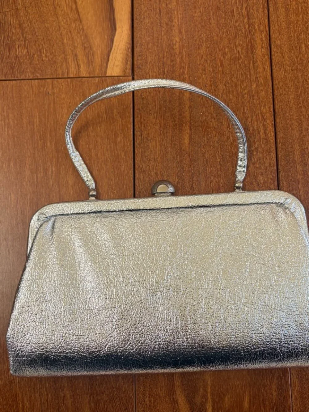 Silver vintage metallic evening clutch with a kiss lock closure and thin strap
